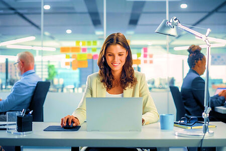 Merchant Credit Card and ACH Processing for Business Professional Services in Florida - Business Woman working at a laptop with two men working on laptops in the background.