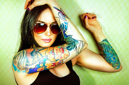 Tattoo Shop and Artist Merchant and ACH Processing - Girl With Colorful Tattoos on Right Arm wearing black tank top, and sunglasses.